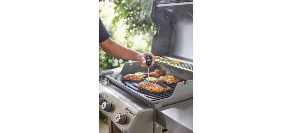 Person using Weber Instant Read Meat Thermometer on grill