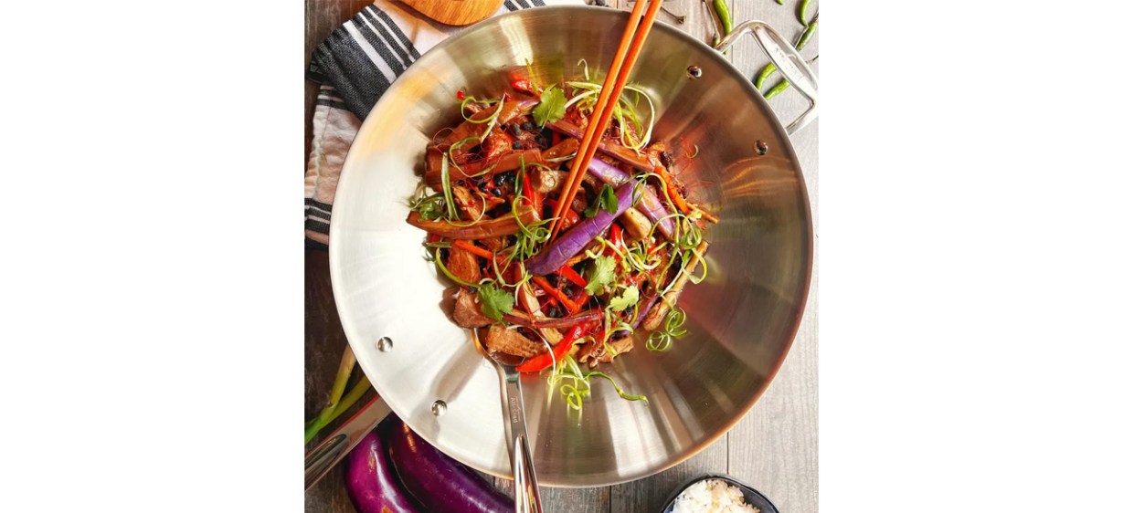 Person making stir-fry in All-Clad D3 Stainless Wok