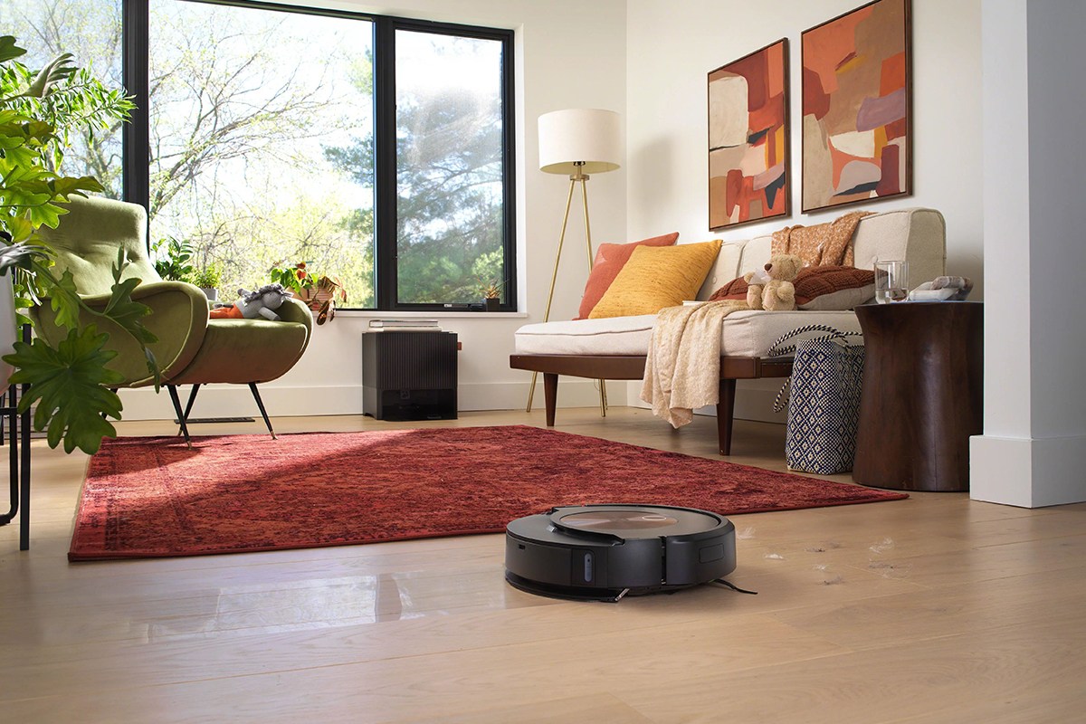 Roomba Combo j9+ on hard floor in living room next to area carpet