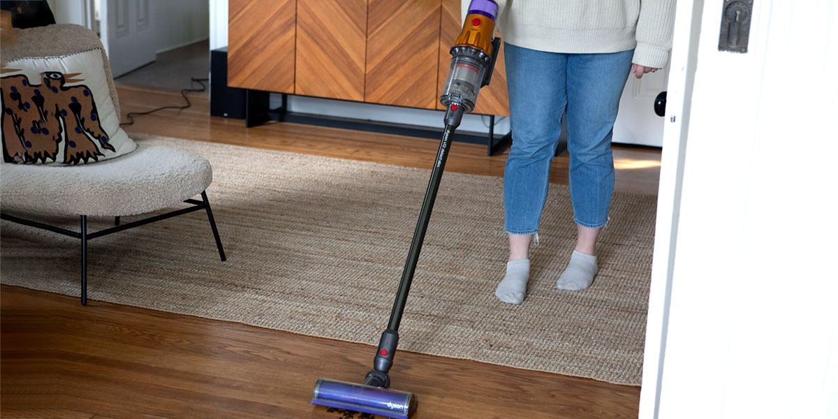 Person using Dyson V15 Detect Cordless Vacuum Cleaner on hardwood flooring