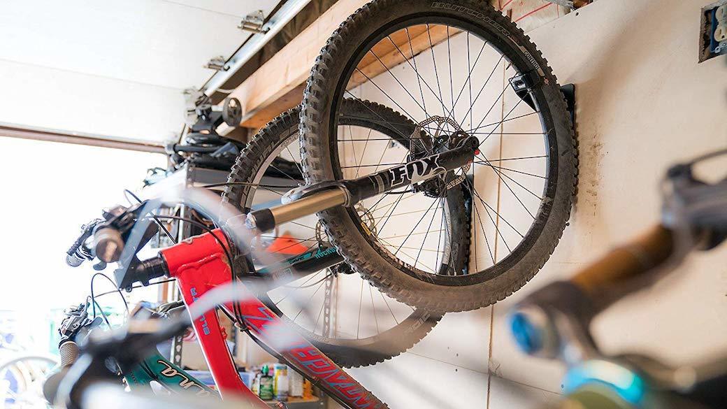 A variety of bicycles hang against a wall.