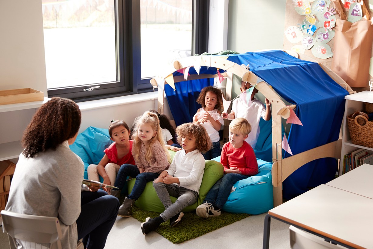 a teacher reading for kids sitting on bean bags
