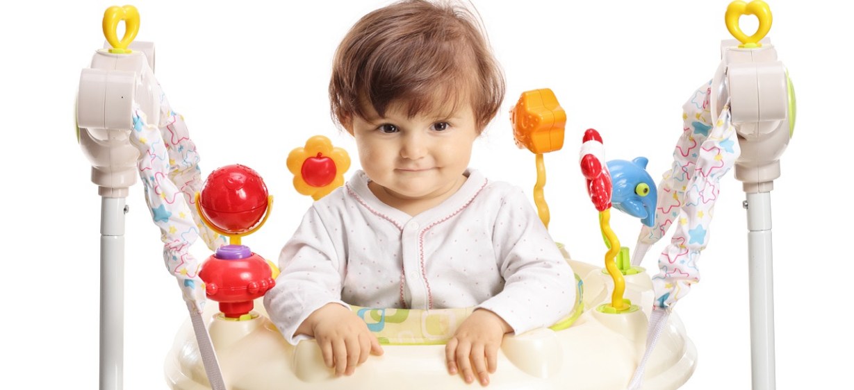 A happy baby uses a baby jumper.