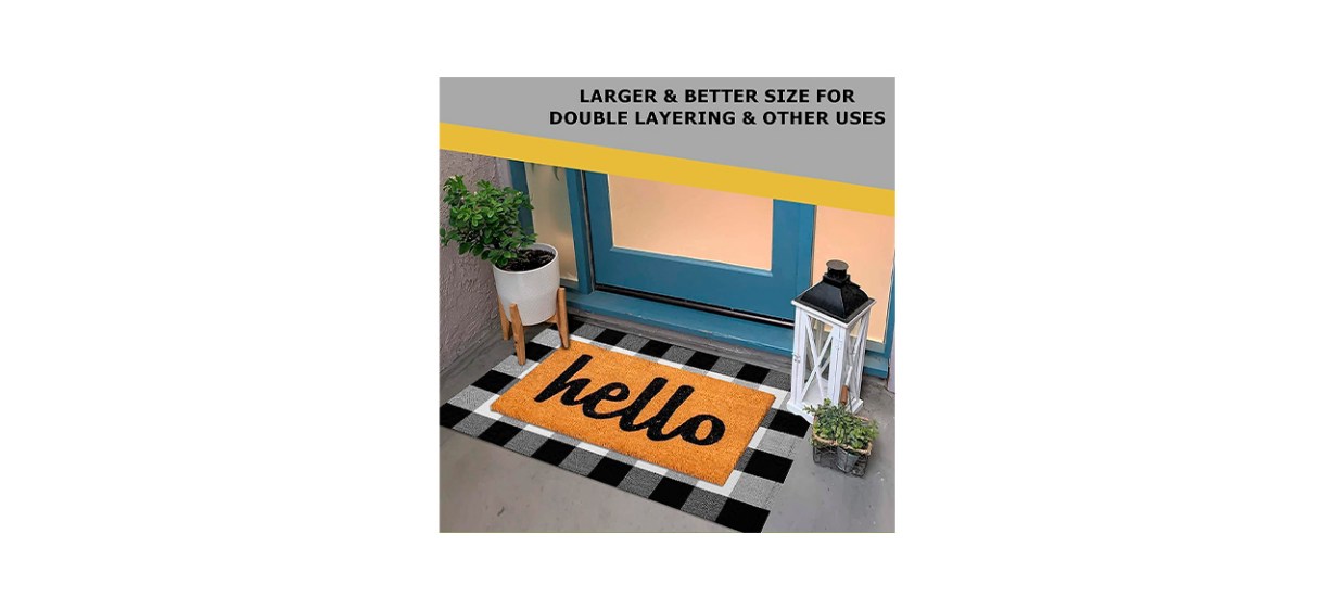 An orange rug that says &quot;hello&quot; on it and has a black and white buffalo plaid border