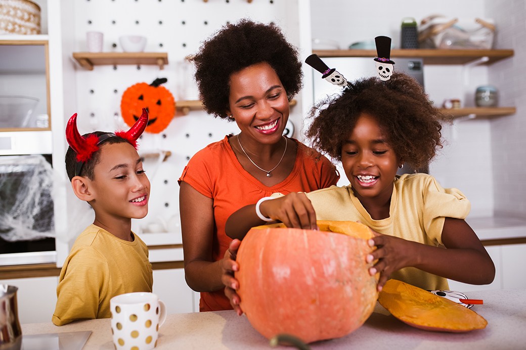 Family carving pumpkin in kitchen