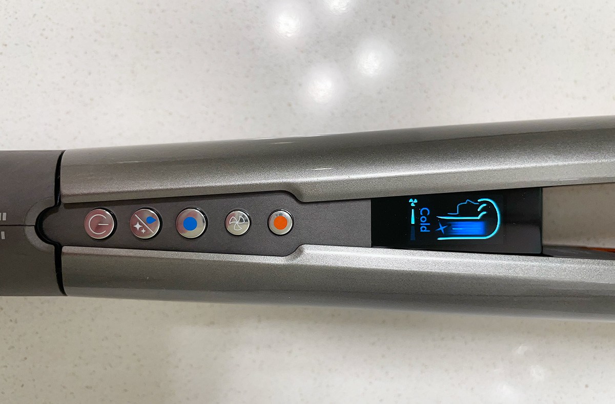 a hair straightener with the word "cold" on its screen