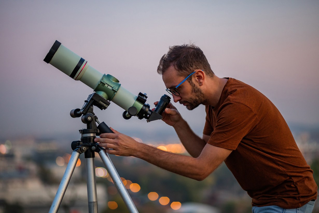 a man looking through a telescope