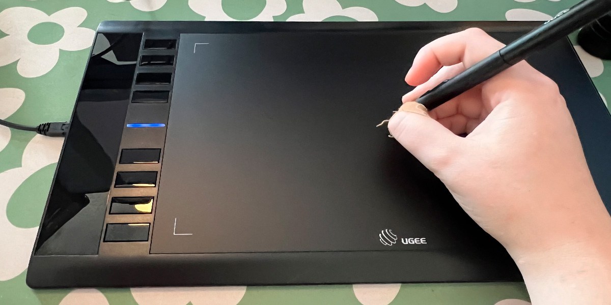 Hand using drawing pen on Ugee M708 Drawing Tablet