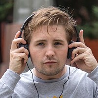 Person putting on headphones in park