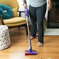 Person vacuuming wood flooring with cordless vacuum